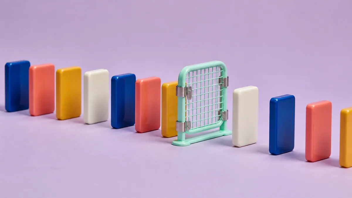 A row of blank cobalt, coral, saffron, and ivory ceramic tiles is interrupted by a mint enamel safety gate on a pale-lavender surface.