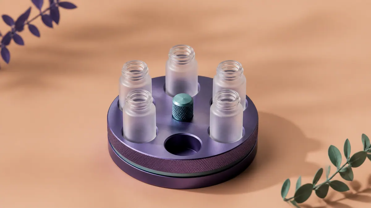 Five empty frosted glass vials sit in a purple sample carousel with one slot vacant against an apricot background.