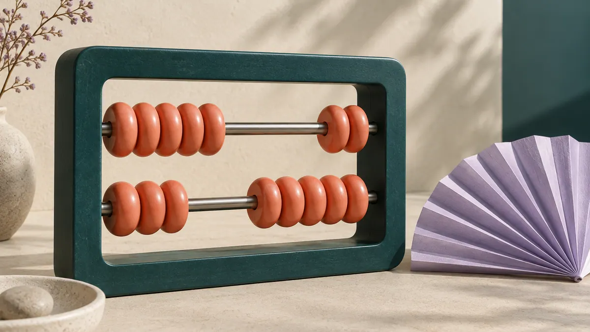 A teal abacus with coral beads stands beside a folded lilac paper fan on a sand-colored tabletop.