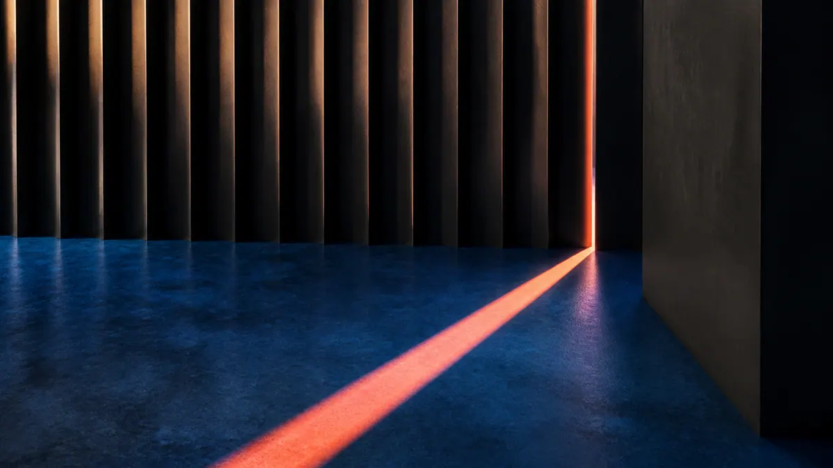 Matte charcoal louvers admit one narrow coral beam across a cobalt floor.