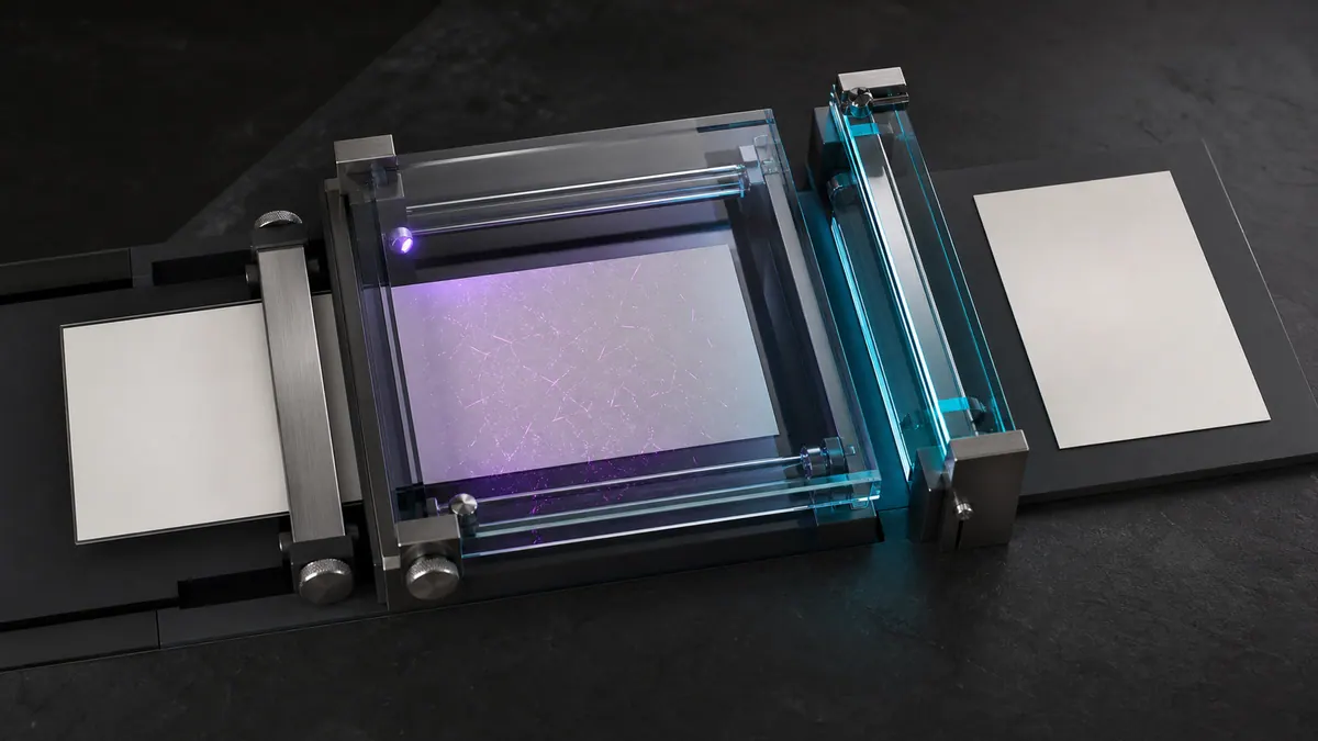 Ivory document passing through a sealed inspection chamber as hidden magenta fibers become visible under violet light